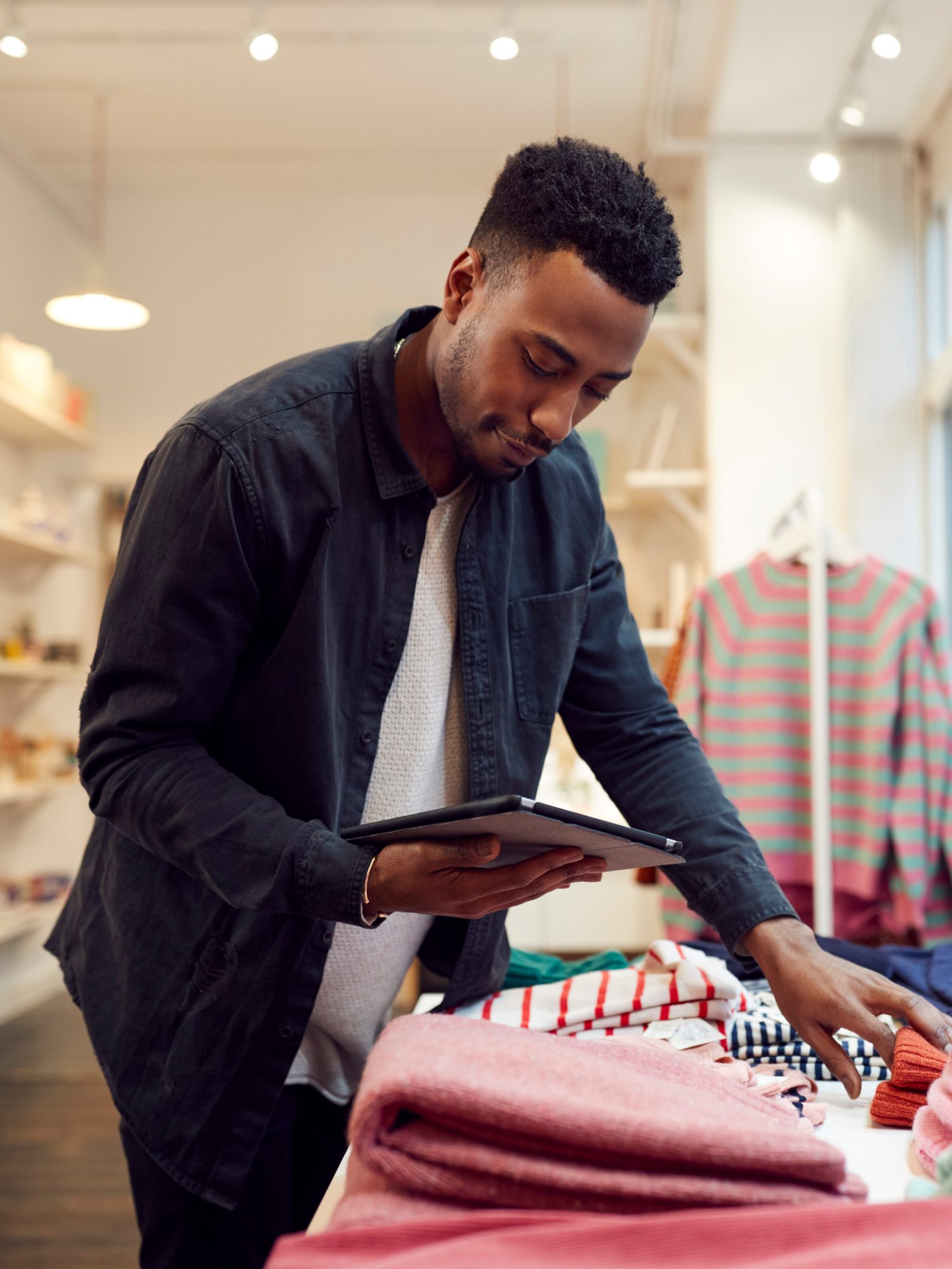 A shop owner checking stock on a tablet